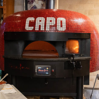 La Posta Pizzeria red tiled rotator brick oven from Marra Forni with wood burning chamber in restaurant